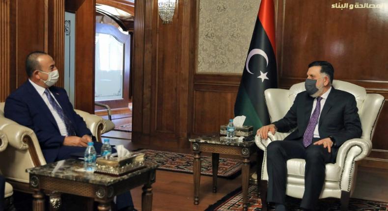 The head of Libya's UN-recognised Government of National Accord Fayez al-Sarraj (R) holds talks in Tripoli with Turkish Foreign Minister Mevlut Cavusoglu whose country backs the GNA in its fight against eastern-based Libya strongman Khalifa Haftar