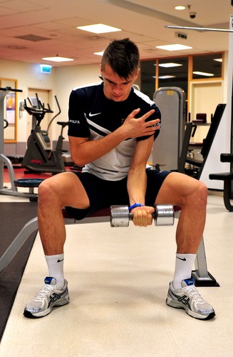 Piłkarz Pogoni Michał Janota podczas ćwiczeń na siłowni