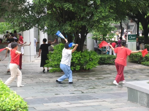 Nierzadki widok na ulicy o poranku. Ludzie tańczą do muzyki. Cwiczenia fizyczne w chińskim stylu.