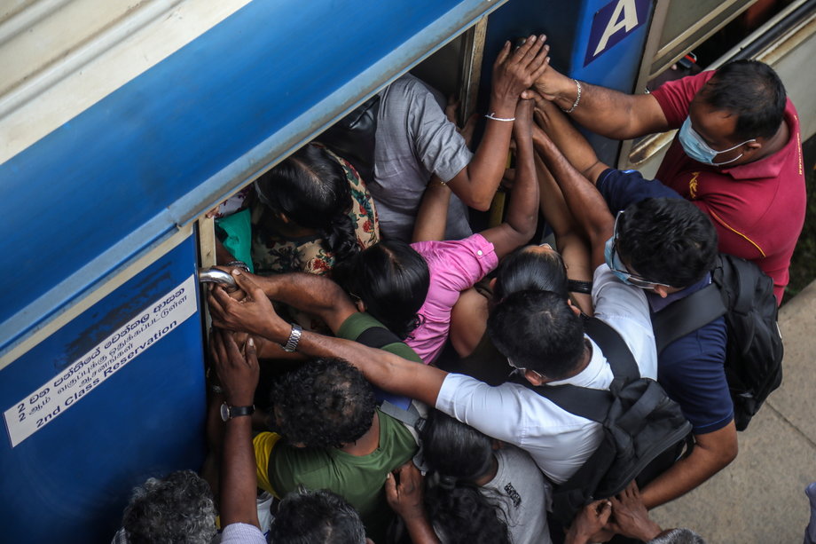 Pasażerowie próbujący wsiąść do przepełnionego pociągu przy braku paliwa w Kolombo na Sri Lance.
