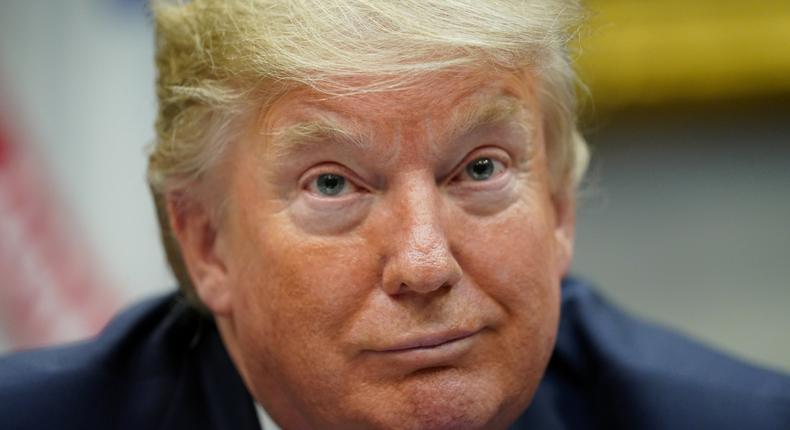 President Donald Trump listens to a question from a reporter while participating in a