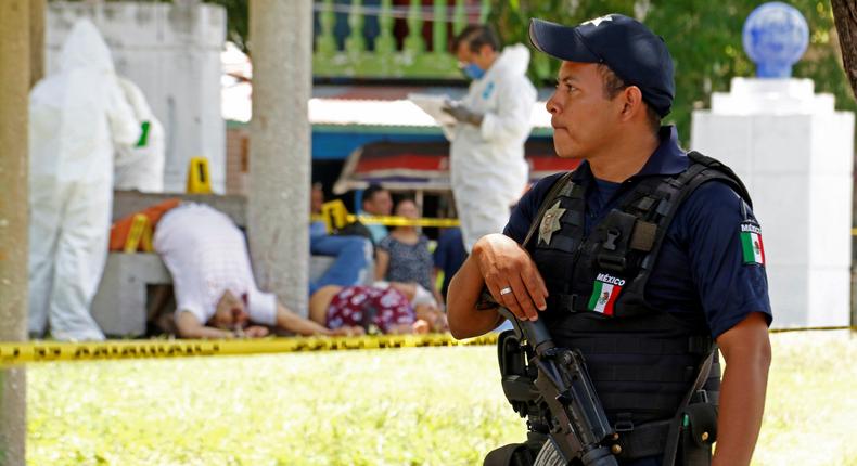 A policeman keeps watch as forensic technicians work at a crime scene where unknown assailants gunned down four persons at a park in Villahermosa, Mexico, July 21, 2017.