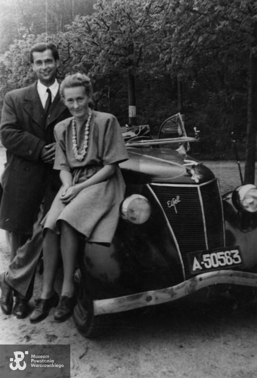 Zofia i Zbigniew Ścibor-Rylscy pozują do zdjęcia przy samochodzie marki Ford Eifel, lata 50. XX wieku