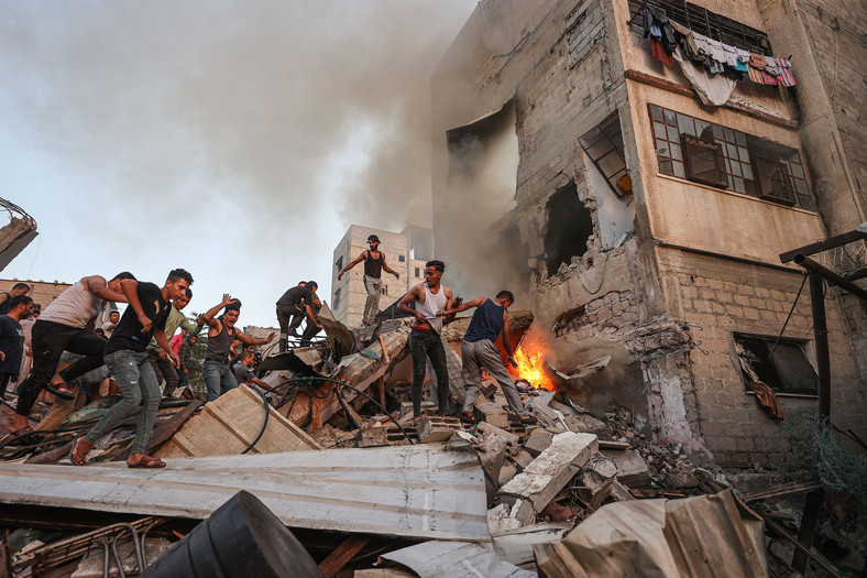 Palestyńczycy na gruzach budynku po izraelskim bombardowaniu na południu Strefy Gazy, 4 listopada 2023 r.