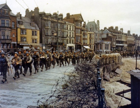 Przygotowania. Żołnierze amerykańscy maszerują w kierunku doków w Weymouth, gdzie wejdą na barki desantowe (czerwiec 1944, domena publiczna).