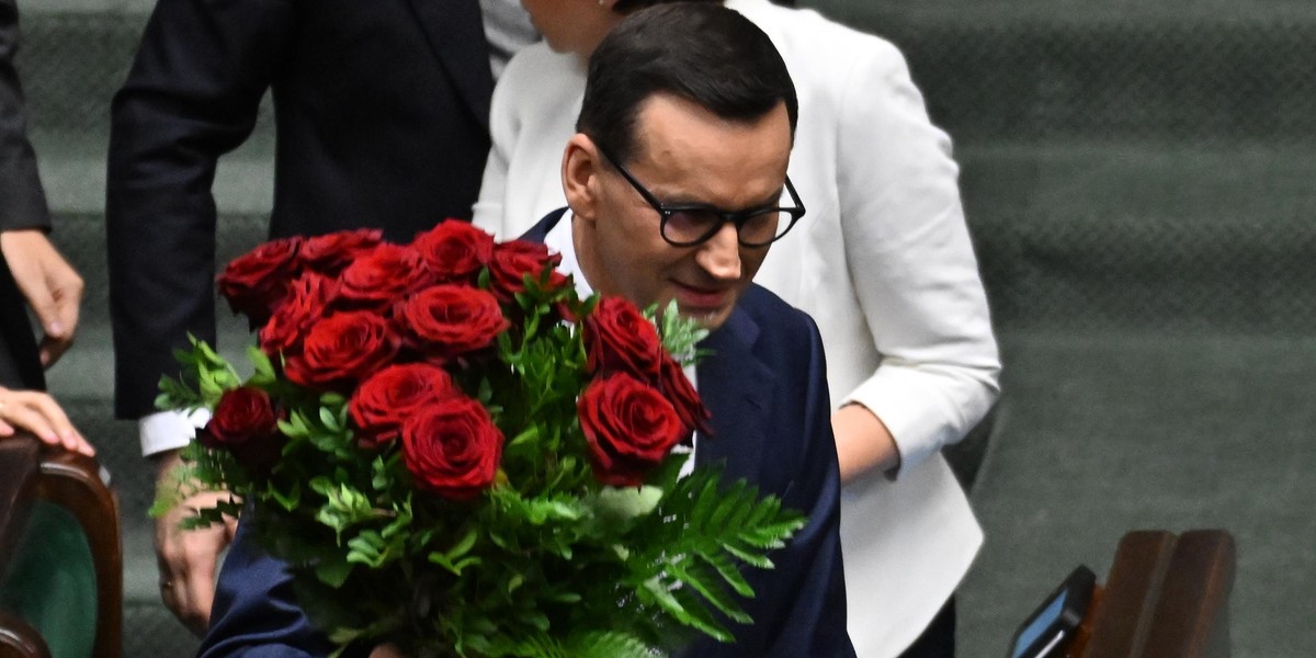 Premier Mateusz Morawiecki przyjmuje kwiaty.