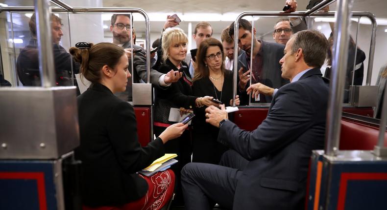 WASHINGTON, DC - NOVEMBER 27: Reporters lean into a subway car while asking Sen. John Thune (R-SD) (R) questions following the weekly Senate Republican policy luncheon in the U.S. Capitol November 27, 2018 in Washington, DC. Republican senators were joined by Vice President Mike Pence and White House Senior Advisor Jared Kushner, President Donald Trump's son-in-law. (Photo by Chip Somodevilla/Getty Images)