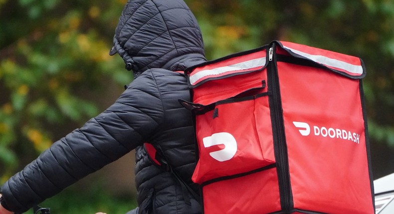 A delivery person for Doordash rides his bike in the rain during the coronavirus disease (COVID-19) pandemic in the Manhattan borough of New York City, New York, U.S., November 13, 2020.