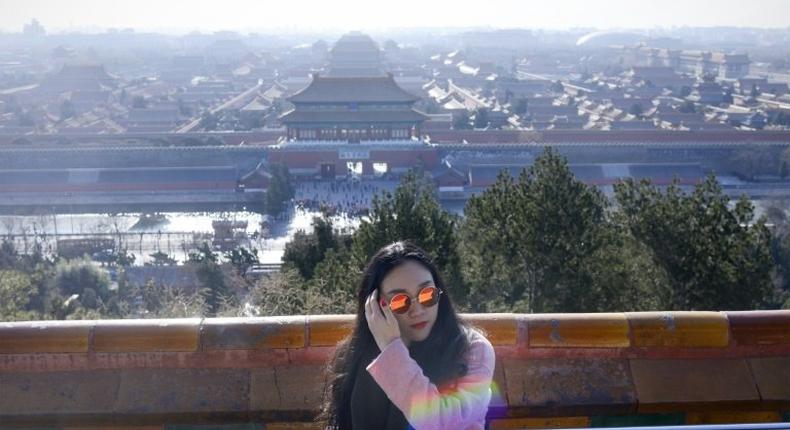 A woman visits a park near the Forbidden City in Beijing on December 22, 2016