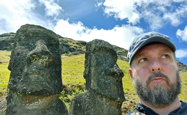 Dominik Maiński na tle figur w kamieniołomie Rano Raraku.