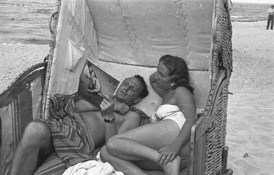 Międzyzdroje, 1948. Wczasowicze w koszu plażowym, mężczyzna czyta "Przekrój"