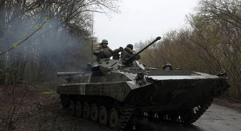 Ukrainian soldiers stand on an armoured personnel carrier (APC), not far from the front-line with Russian troops, in Izyum district, Kharkiv region on April 18, 2022.