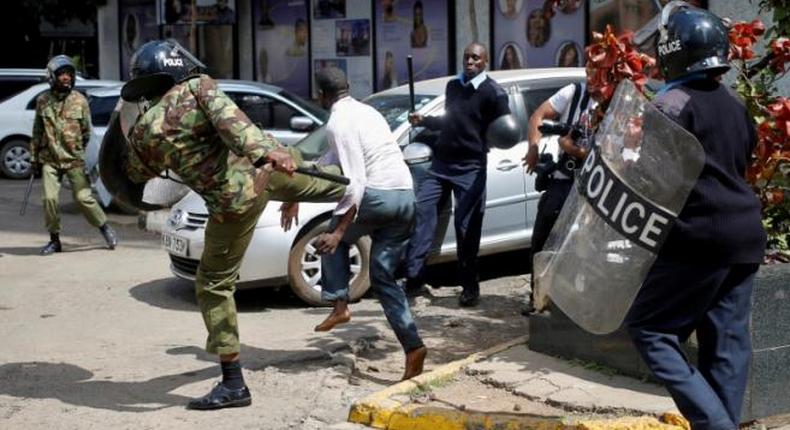  Kenyan policemen beat a protester during clashes in Nairobi, Kenya May 16, 2016. 