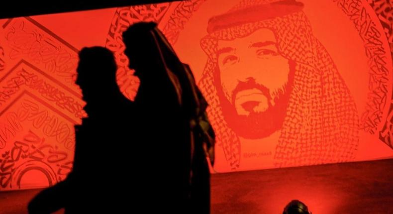 Saudis walk next to a portrait of Crown Prince Mohammed bin Salman at the Riyadh Season Boulevard in the Saudi capital.FAYEZ NURELDINE/AFP via Getty Images
