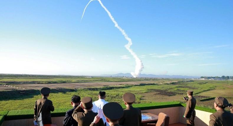 North Korean leader Kim Jong-Un (C, in white shirt) watches the test of a new anti-aircraft guided weapon system organized by the Academy of National Defence Science at an undisclosed location, in an undated picture released on May 28, 2017