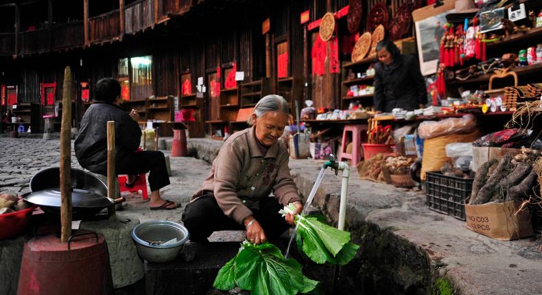 Elderly lady washing vegetables inside a tulou in Fujian, China.Sheng Li/Reuters