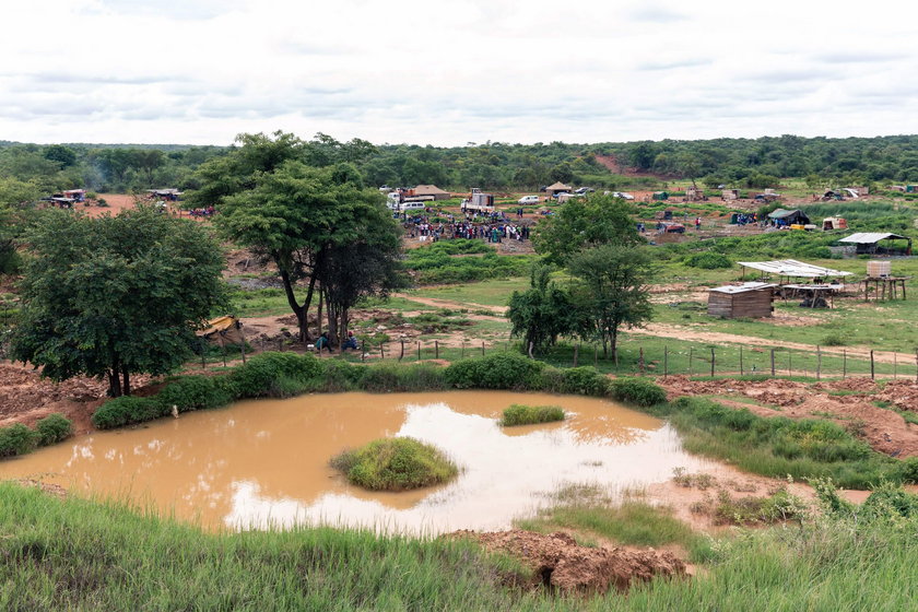 An artisanal miner stands near a shaft as retrieval efforts proceed for trapped illegal gold miners 