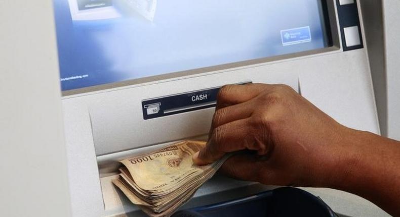 A woman takes Nigerian Naira from a bank's automated teller machine (ATM) in Ikeja district in the commercial capital Lagos November 12, 2014. REUTERS/Akintunde Akinleye