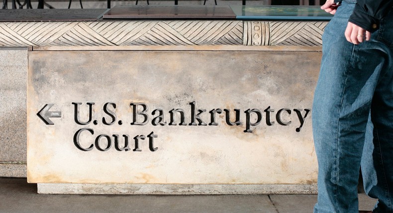 A man walks in front of a United States Bankruptcy Court sign in New York City.Steven Puetzer/Photographer's Choice RF via Getty Images