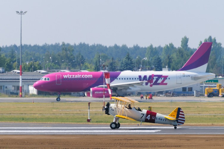 Boeing Stearman (front) na tle kołującego samolotu pasażerskiego podczas pokazu lotniczego, 13 bm. Na poznańskim lotnisku Ławica odbywają się pokazy lotnicze Aerofestival 2015. (jk/cat) PAP/Jakub Kaczmarczyk