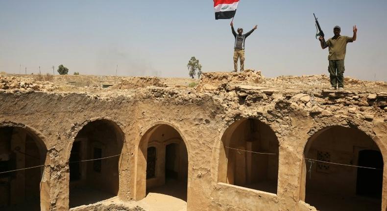 Fighters from the Hashed al-Shaabi paramilitary group raise the Iraqi flag over Tal Afar's historic Ottoman-era citadel after they and Iraqi forces seized it from Islamic State group jihadists