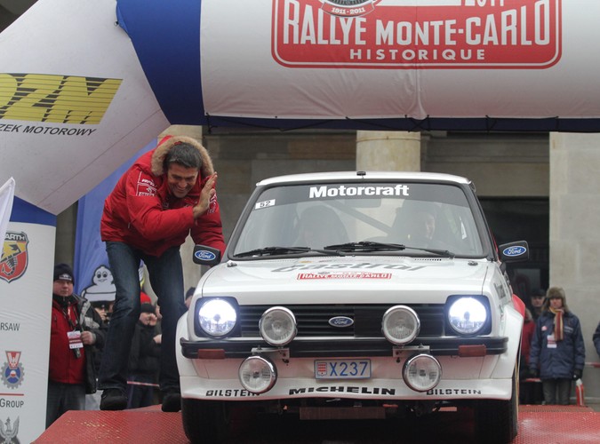 Krzysztof Hołowczyc pozdrawia belgijską załogę Bruno Thiry / Nicolas Gilsoul w samochodzie Ford Fiesta na starcie do XIV Rajdu Monte Carlo Samochodów Historycznych