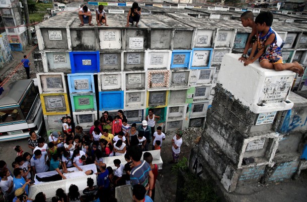 Loved ones and mourners surround the coffins of Maximo Pepito and his brother Marlon Pepito, victims