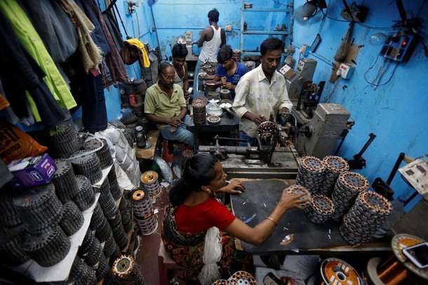 Workers assemble ceiling fan motors at a workshop in Kolkata