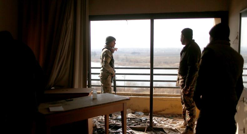 Iraqi soldiers looking out from a damaged room in the Ninewah Oberoi Hotel in Mosul.