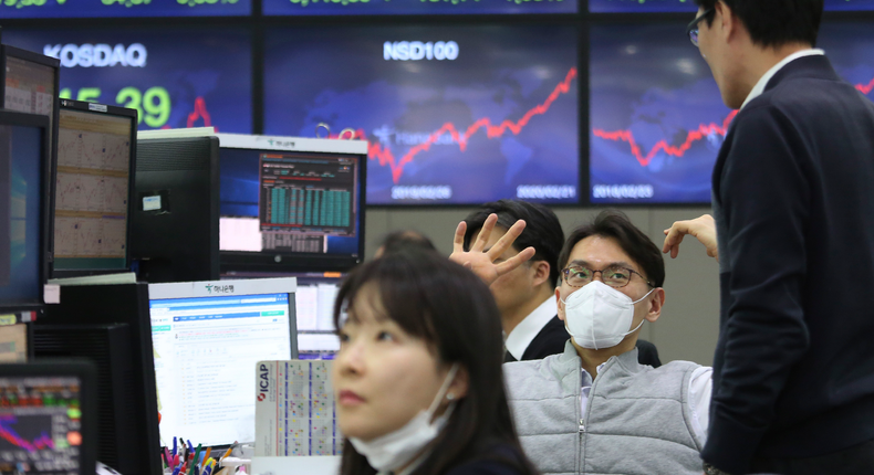 A currency trader wears a face mask at the foreign exchange dealing room of the KEB Hana Bank headquarters in Seoul, South Korea, Monday, Feb. 24, 2020. (AP Photo/Ahn Young-joon)