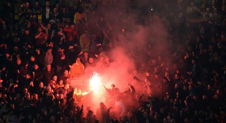 Liverpool supporters light flares during their Europa League clash with Manchester United at Old Trafford on March 17, 2016