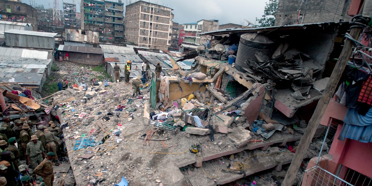 Kenyan police officers and Kenyan National Youth Servicemen search the site of a building collapse in Nairobi, Kenya, Saturday, April 30, 2016.