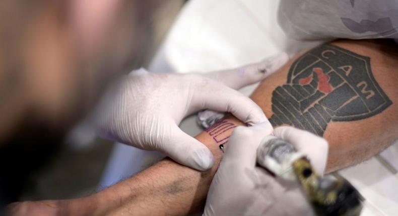 A fan of Brazilian team Atletico Mineiro gets a free tattoo offered by the company constructing the new stadium after the squad won the Brazilian Championship Creator: Douglas MAGNO