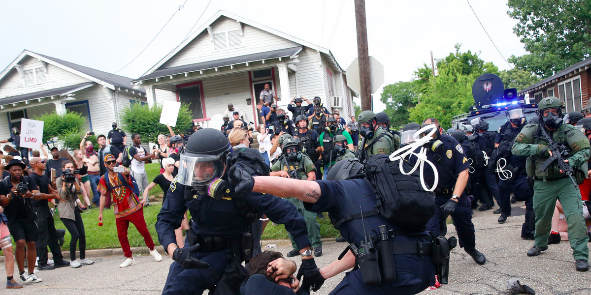 Police scuffle with a demonstrator as they try to apprehend him during a rally in Baton Rouge, Louisiana U.S. July 10, 2016.