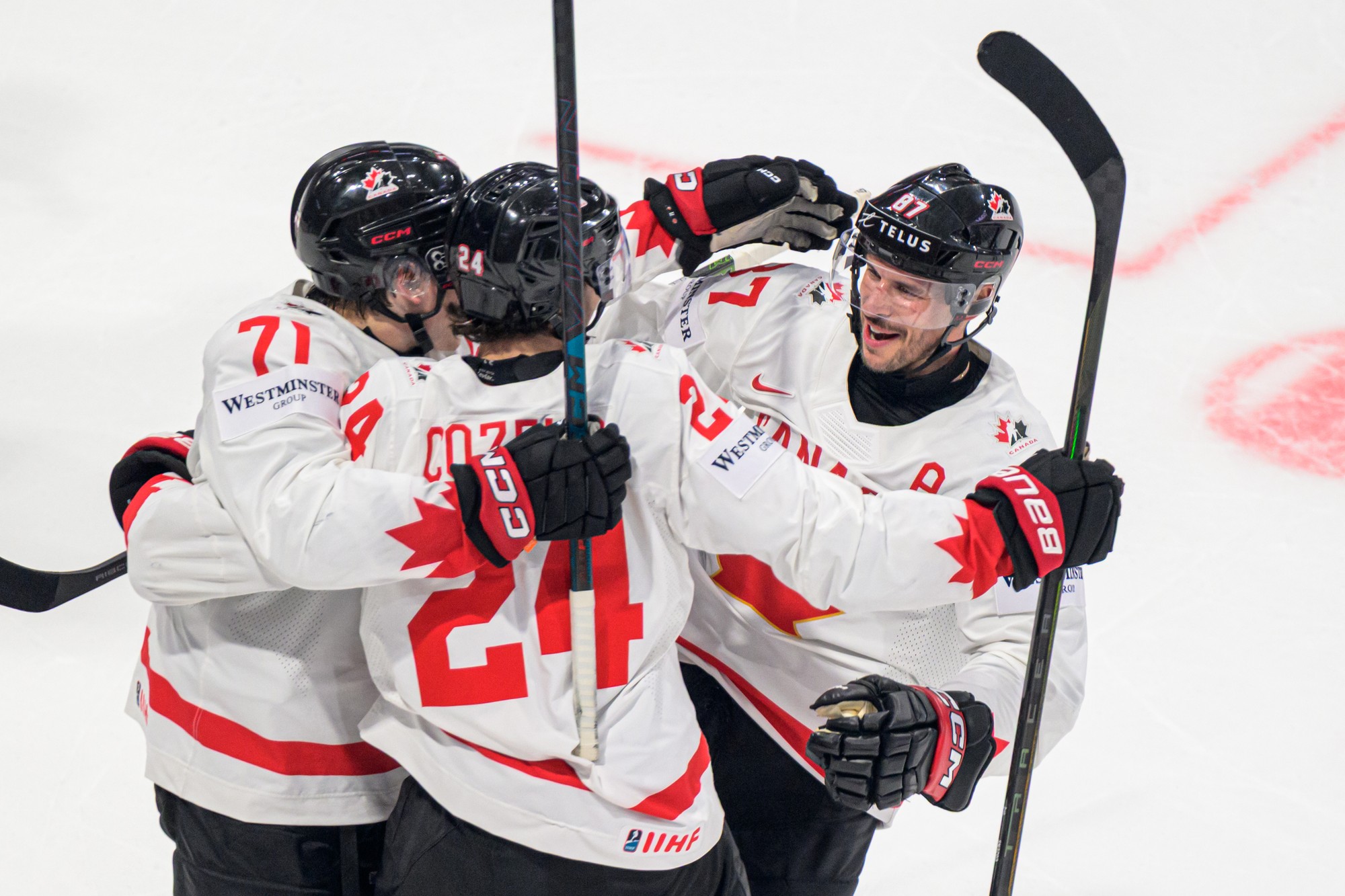 Zľava Macklin Celebrini, Dylan Cozens a Sidney Crosby sa tešia z prvého gólu Kanady. 