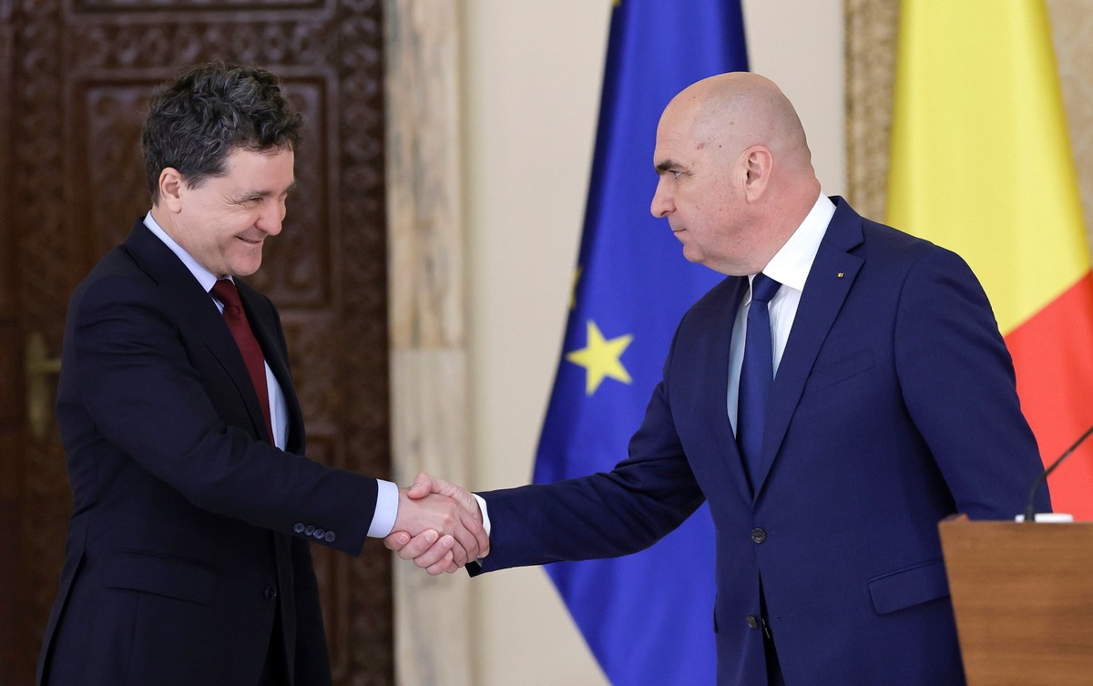 Prezydent Rumunii Nicusor Dan (L) i nominowany premier Ilie Bolojan (P) uścisnęli sobie dłonie na zakończenie wspólnej konferencji prasowej w pałacu prezydenckim Cotroceni w Bukareszcie