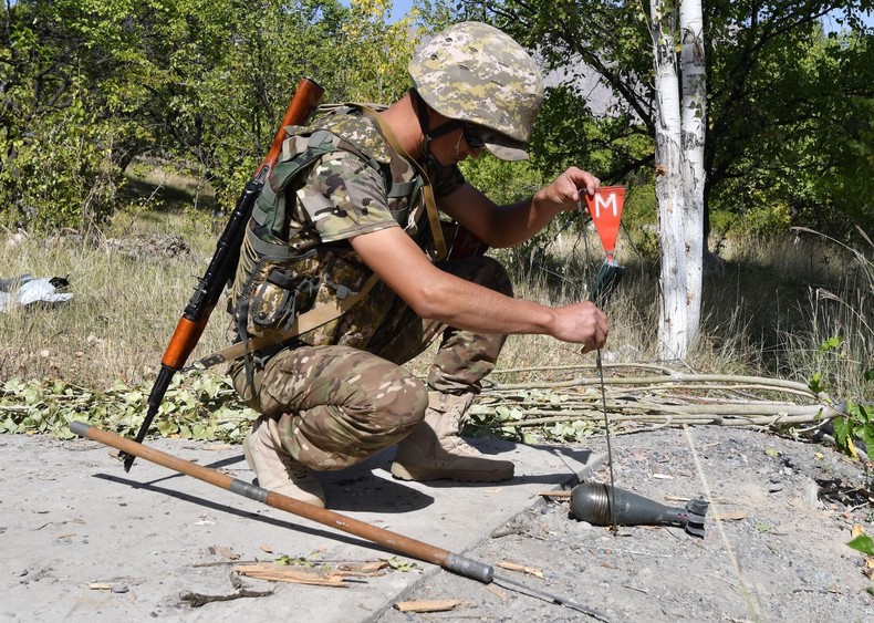 Kyrgyz troops look for unexploded shells in a village near the Kyrgyz-Tajik border on September 20.VYACHESLAV OSELEDKO/AFP via Getty Images