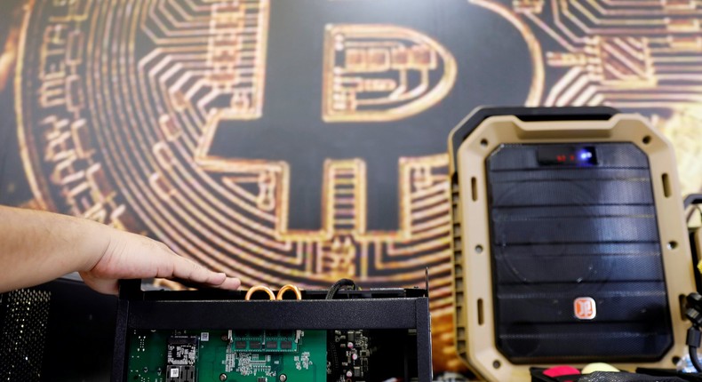 FILE PHOTO: A cryptocurrency mining computer is seen in front of bitcoin logo during the annual Computex computer exhibition in Taipei, Taiwan June 5, 2018. REUTERS/Tyrone Siu