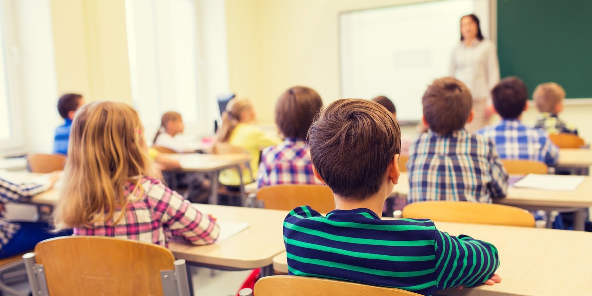 group of school kids and teacher in classroom