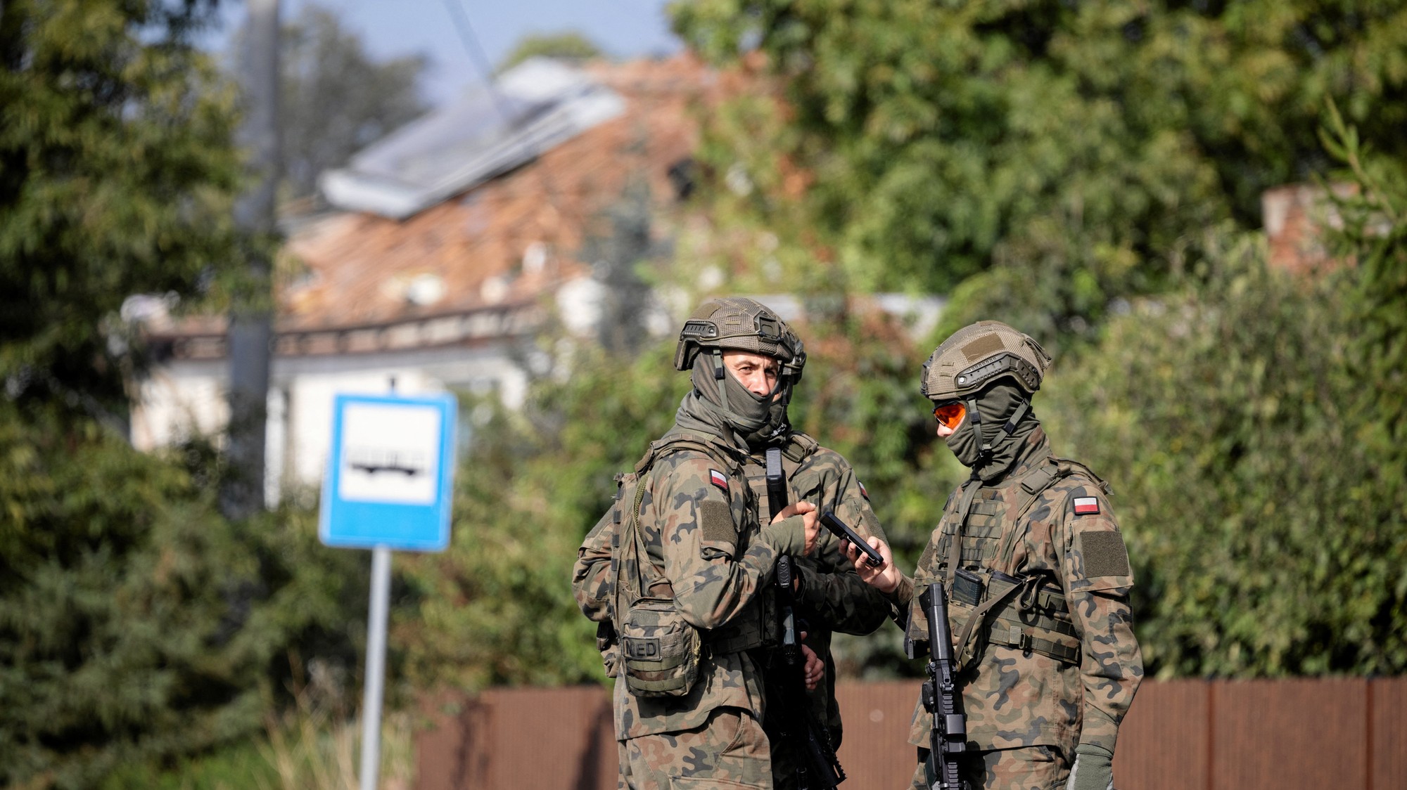 Vojáci hliadkujú na ulici po tom, čo podľa miestnych úradov zasiahol dron alebo podobný objekt obytnú budovu v dôsledku narušenia poľského vzdušného priestoru počas ruského útoku na Ukrajinu v meste Wyryki-Polod v Poľsku.
