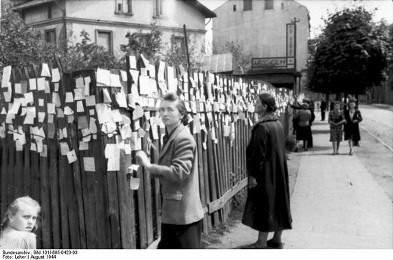 Kobiety szukają informacji o zaginionej rodzinie w Pruszkowie pod Warszawą. (fot. Bundesarchiv, Bild 101I-695-0423-03 / Leher. Opublikowano na licencji Creative Commons Uznanie autorstwa-Na tych samych warunkach 3.0 Unported)