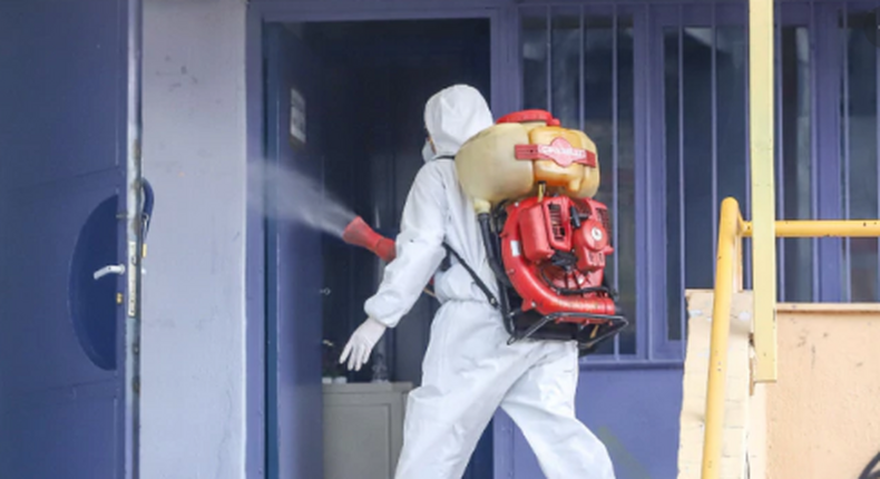 Illustrative image of a man in a protective suit, disinfecting a school facility where a child was diagnosed with coronavirus, in Thessaloniki, Greece. [Reuters]