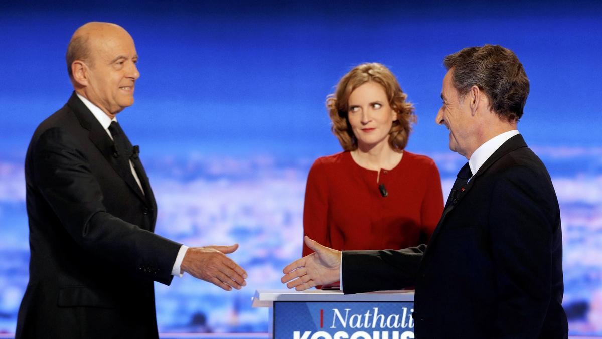 French politicians Alain Juppe and Nicolas Sarkozy shake hands as Nathalie Kosciusko-Morizet looks 