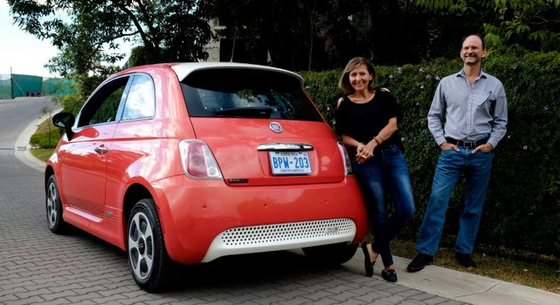 Costa Rican Erick Orlich (R) and his wife Gioconda Rojas (L) run two electric cars powered by solar panels installed on the roof of their house