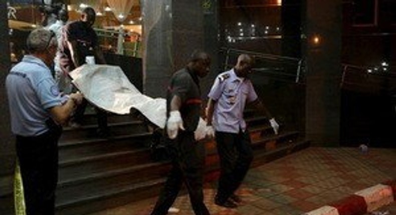 Malian officials carry a corpse outside the Radisson hotel in Bamako, Mali, November 20, 2015. REUTERS/Joe Penney