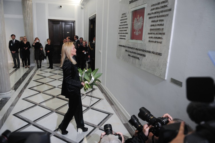 Sharon Stone w polskim Sejmie składa kwiaty pod tablicą upamiętniającą ofiary katastrofy w Smoleńsku