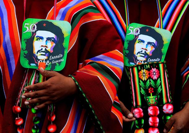 Aymara men hold images of Ernesto Che Guevara as they attend a ceremony to commemorate Che Guevara's