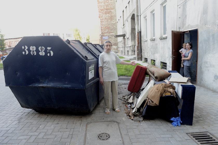 Kobieta przed śmietnikiem