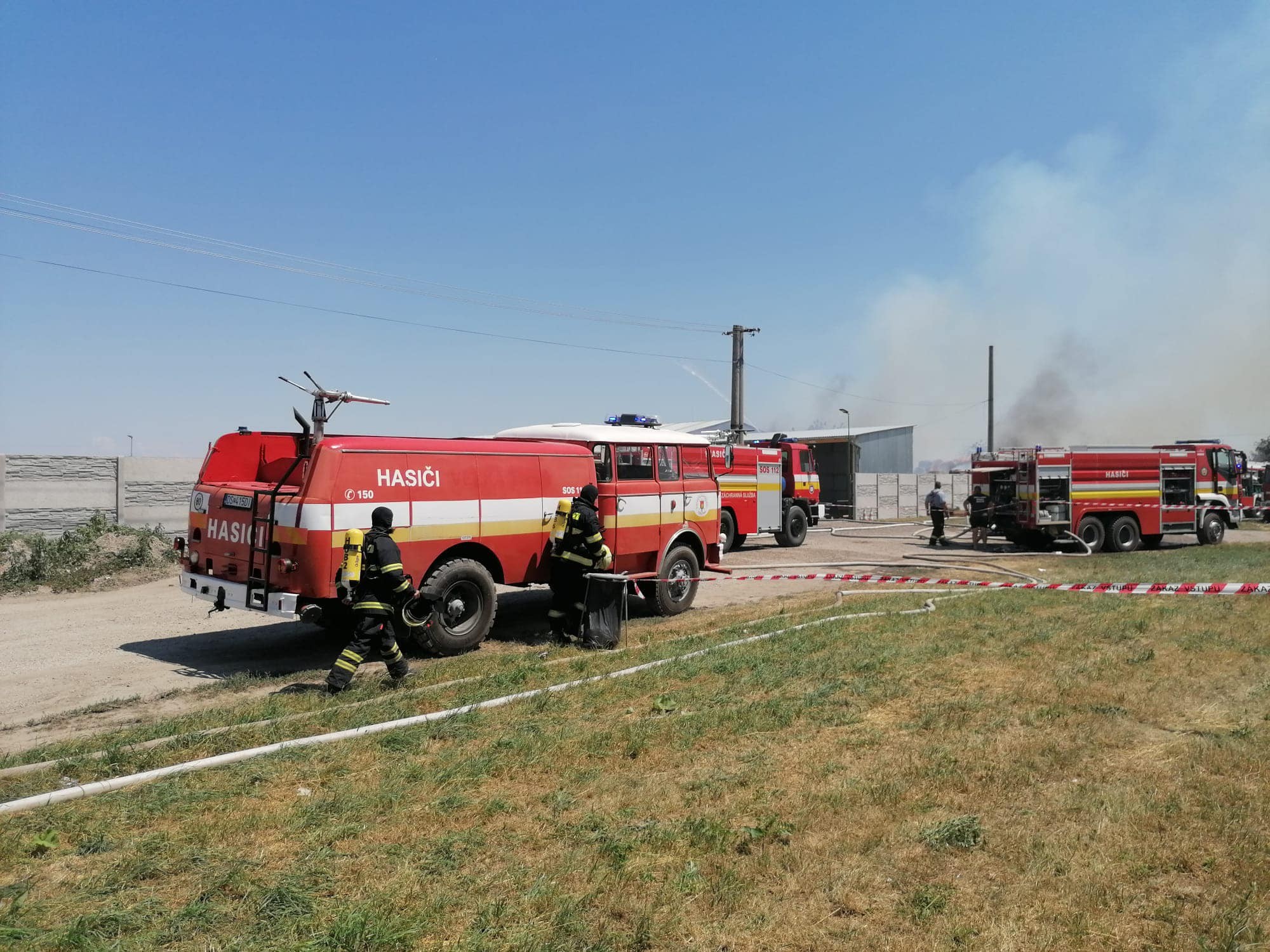 Hasiči likvidujú požiar uskladnených kartónov v obci Kostolné Kračany.