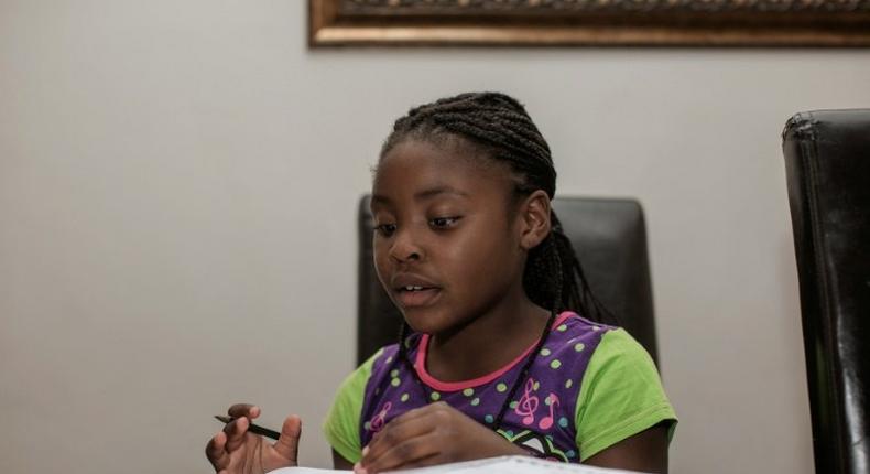 Seven-year-old author Michelle Nkamankeng does her homework at her house in Johannesburg, South Africa